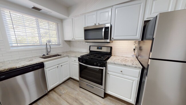 Cocina renovada con gabinetes estilo shaker y manijas de cromo cepillado - Alister Falls Church