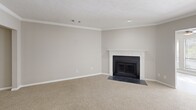 This well-appointed single-story home in Columbus, GA offers three bedrooms and three full bathrooms across a generously sized floor plan. The kitchen is a functional centerpiece, featuring white shaker cabinets, granite countertops, a tile backsplash, stainless steel appliances including a range, microwave, refrigerator, and dishwasher, along with a peninsula with a double sink — ideal for both cooking and casual dining. The living room is highlighted by a classic wood-burning fireplace with a white mantel surround, crown molding, and plush carpeting that adds warmth to the space. Bedrooms are carpeted and filled with natural light from blinded windows; secondary bedrooms include ceiling fans and closets with built-in shelving. The spacious primary bedroom connects to a well-sized walk-in closet with wire shelving. The primary bathroom is a standout feature, offering a raised soaking tub with steps, granite vanity countertops, white cabinetry, and luxury vinyl plank flooring. Additional bathrooms are clean and functional, with consistent finishes throughout. Wood-look LVP flooring flows through the main living areas, tying the home together with a cohesive, neutral aesthetic.