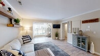 Located at 1001 Riverland Woods Pl in Charleston, SC, this well-appointed 2-bedroom, 2-bathroom single-story home offers a thoughtfully designed layout with a warm, contemporary aesthetic. Light-toned hardwood-style flooring flows throughout, complemented by neutral walls and crown molding that add a refined touch.

The open living area is spacious and inviting, featuring large windows that flood the room with natural light. The kitchen is well-equipped with crisp white cabinetry, granite countertops, and stainless steel appliances, seamlessly connecting to a dedicated dining area accented by crown molding. The combined living and dining space provides a comfortable flow ideal for everyday living and entertaining.

The primary bedroom is generously sized and includes a walk-in closet with built-in wire shelving and an en-suite bathroom featuring granite countertops and white cabinetry. The second bedroom is comfortably proportioned with natural light, a panel-style closet, and hardwood-style flooring. Both bathrooms are finished with granite vanity tops and modern hardware.

Additional highlights include a dedicated closet for extra storage. The overall ambiance is bright, clean, and cohesive, making this Charleston home a comfortable and functional living space.