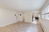 Located at 1550 Detroit Street in Denver's desirable Congress Park neighborhood, this single-floor unit offers a thoughtfully utilized layout across its compact footprint. The living area features light wood-style flooring and crisp white walls, with a wide window that invites natural light and provides street-level views, creating an open and airy atmosphere. Baseboard heating runs along the walls, ensuring comfort throughout the space.

The kitchen is efficiently designed with white cabinetry, warm wood-toned upper cabinets, classic white subway tile backsplash, and durable tile flooring. It is equipped with stainless steel appliances, including an electric range and a black refrigerator, and features a window that brings in additional natural light.

Two bathrooms serve the unit, offering practical functionality. One bathroom showcases a standout tiled tub and shower surround with elegant marble-style porcelain tiles, a decorative mosaic niche, wood-style flooring, and clean white finishes throughout.

A narrow hallway connects the rooms, finished with the same light wood-style flooring and bright white walls that carry through the entire unit, lending a cohesive and clean aesthetic. This unit is ideal for those seeking a well-located, low-maintenance space in one of Denver's vibrant urban neighborhoods.