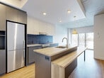 Located at 5250 Rue Molson in Montréal's dynamic Rosemont–La Petite-Patrie district, this well-designed one-bedroom, one-bathroom unit offers a thoughtfully laid-out living space with modern finishes throughout. The open-concept kitchen is a standout feature, showcasing two-tone cabinetry in warm cream and charcoal grey, a bold hexagonal tile backsplash, stainless steel appliances, and a generous island with a warm wood-tone countertop that doubles as a dining surface. A pendant light fixture adds a stylish accent, while a large sliding door brings in abundant natural light and connects the space to the outdoors. Warm honey-toned hardwood flooring flows consistently throughout, complementing the contemporary palette. The bedroom is a well-proportioned retreat, equipped with built-in floor-to-ceiling storage in matching grey cabinetry, offering ample organization with a clean, minimal aesthetic. Exposed concrete ceiling details lend an urban, loft-inspired character to the room. The bathroom continues the modern design language with a grey vanity, mirrored medicine cabinet, and crisp white walls. A separate laundry closet with a stacked washer and dryer unit adds everyday convenience. This unit combines efficient use of space with high-quality finishes for a refined urban living experience.