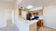 This one-bedroom, one-bathroom unit in Fort Worth, Texas offers a well-organized single-floor layout designed for comfortable everyday living. The open kitchen and dining area features warm wood cabinetry, marble-look countertops, a peninsula with a built-in sink, and black appliances including a range, microwave, and refrigerator. Wood-look flooring runs through the kitchen, providing easy maintenance, while carpet carries through the remaining living areas. The living room is a standout space, anchored by a marble-surround fireplace and a sliding glass door that opens directly onto a private patio with views of the surrounding landscaped community. The bedroom is a comfortable, carpeted retreat with a ceiling fan, natural light from two windows, and its own sliding glass door access. The bathroom includes a wood-vanity with marble-look countertop, a tub-shower combo with white tile surround, and wood-look flooring. Two closets provide ample storage, and a dedicated laundry area adds everyday convenience. The patio offers an open-air outdoor space with scenic community views under wide Texas skies, making it an ideal spot to relax.