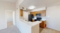 This one-bedroom, one-bathroom unit in Fort Worth, Texas offers a well-organized single-floor layout designed for comfortable everyday living. The open kitchen and dining area features warm wood cabinetry, marble-look countertops, a peninsula with a built-in sink, and black appliances including a range, microwave, and refrigerator. Wood-look flooring runs through the kitchen, providing easy maintenance, while carpet carries through the remaining living areas. The living room is a standout space, anchored by a marble-surround fireplace and a sliding glass door that opens directly onto a private patio with views of the surrounding landscaped community. The bedroom is a comfortable, carpeted retreat with a ceiling fan, natural light from two windows, and its own sliding glass door access. The bathroom includes a wood-vanity with marble-look countertop, a tub-shower combo with white tile surround, and wood-look flooring. Two closets provide ample storage, and a dedicated laundry area adds everyday convenience. The patio offers an open-air outdoor space with scenic community views under wide Texas skies, making it an ideal spot to relax.