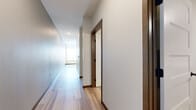 Located at 5401 94th Ave N in Brooklyn Park, Minnesota, this single-floor unit offers a thoughtfully designed layout that maximizes functionality and comfort. Light wood-style flooring runs throughout the main living areas, lending a clean, contemporary feel that ties the space together cohesively.

The kitchen is a standout feature, showcasing white shaker-style cabinetry with black hardware, granite countertops, a classic white subway tile backsplash, and a full suite of stainless steel appliances including a refrigerator, range, microwave, and dishwasher. A built-in sink with a modern faucet completes the well-equipped culinary space.

A bright hallway with warm-toned door trim connects the rooms, providing easy access to each area of the unit. The bedroom is carpeted for comfort, features rich dark baseboards, a ceiling fan, and includes a closet with built-in wire shelving for organized storage.

The bathroom is finished with wood-style tile flooring, a granite-topped vanity with matching black hardware, and a full tub-shower combination with a curved curtain rod.

A dedicated laundry room with wire shelving and an in-unit washer adds everyday convenience. The overall design is clean and modern, with neutral tones and quality finishes throughout.