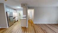 Located at 650 N Wilcox Dr in Kingsport, Tennessee, this single-floor residence offers a clean, modern aesthetic with thoughtfully updated finishes throughout. The open-concept kitchen is a functional highlight, featuring white cabinetry with contemporary hardware, a subway tile backsplash, stainless steel appliances including a refrigerator and electric range, and light wood-tone luxury vinyl plank flooring. A peninsula-style counter divides the kitchen from the adjoining hallway, enhancing the sense of flow between spaces. The living area is bright and welcoming, with the same wood-tone flooring and neutral wall tones, and opens to the outdoors through a set of glass French doors that invite natural light. Bedrooms offer plush carpeting, neutral walls, and ample natural light from windows with exterior views. Closet space is well-represented, including a bedroom with an adjacent walk-in style closet with wire shelving. The bathrooms are finished with wood-tone vinyl flooring, white fixtures, and combination tub-shower units. A dedicated laundry area is also accessible from the kitchen. Textured ceilings and white panel doors are consistent design elements throughout, contributing to a cohesive and tidy interior presentation.