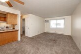 Located at 3200 Indianola Ave in Des Moines, Iowa, this one-bedroom, one-bathroom unit offers a practical and well-organized layout across a single floor. The open living room provides a comfortable, carpeted space accented by a ceiling fan with light fixture and a textured ceiling. A wall-mounted air conditioning unit and baseboard heating ensure year-round comfort, while a window allows natural light to fill the room. The kitchen sits adjacent to the living area, separated by a half-wall breakfast bar with warm wood cabinetry, a sink, and white appliances, creating a semi-open feel ideal for everyday living. A hallway connects the main living spaces to the private bedroom, which features plush carpeting, a ceiling fan, a window with blinds overlooking the exterior, and a baseboard heater. The bedroom includes a generously sized closet with sliding doors, offering ample storage. A second closet provides additional storage space. The bathroom is clean and straightforward, featuring a tub/shower combination with built-in shelving, tile flooring, and crisp white finishes throughout. This unit delivers a functional, comfortable living environment well-suited for those seeking a streamlined and efficient home in Des Moines.