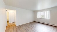 This 1-bedroom, 1-bathroom unit in Warren, Michigan offers a clean, modern aesthetic with consistent light-toned hardwood-style flooring running throughout the entire space. The living room is comfortably sized, featuring large windows with vertical blinds that allow generous natural light to fill the room, along with a ceiling fan and baseboard heating. The layout flows naturally through two hallways that connect the main living areas to the private spaces.

The galley-style kitchen is a standout feature, outfitted with dark espresso cabinetry, light marble-look countertops, a stainless steel sink with a matte black faucet, a gas range, and a black refrigerator. A window and ceiling fan provide ventilation and additional light. Ample upper and lower cabinet storage makes this kitchen as practical as it is attractive.

The bedroom is a well-proportioned, quiet retreat with a window, baseboard heating, and crisp white walls. The bathroom continues the modern design language with a dark-toned vanity, white countertop, wood-look flooring, a full bathtub with shower, and matte black hardware and accessories. The overall ambiance of the unit is bright, clean, and move-in ready, with updated finishes that give the space a fresh, contemporary feel.