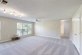 This single-floor, 2-bedroom, 2-bathroom home at 3624 Belmont St in Greensboro, NC offers a well-organized layout across a comfortable footprint. The two living areas are generously sized, featuring soft carpet flooring, neutral-toned walls, textured ceilings, and ceiling fans for year-round comfort. Large windows allow abundant natural light to fill the rooms while providing views of surrounding greenery. Track lighting provides additional illumination in key areas.

The kitchen is a functional and attractive space, featuring rich dark wood cabinetry, granite-look countertops, wood-style flooring, and black appliances including a refrigerator, range, and built-in microwave. Both bathrooms are finished with wood-style vinyl flooring and include tub/shower combinations with curved curtain rods and clean white fixtures.

The two bedrooms are carpeted and well-proportioned, each equipped with a ceiling fan and window for natural light. The primary bedroom offers a notably spacious layout with closet access. Additional spaces include a utility room, a hallway, and two closets, providing ample storage. The overall ambiance of the home is clean, neutral, and move-in ready, making it a practical and comfortable residence in Greensboro.