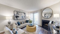 Located at 100 Reflections Circle in Casselberry, FL, this thoughtfully designed 2-bedroom, 2-bathroom single-floor residence offers a comfortable and stylish living experience. The entryway welcomes you with wood-look flooring and a smart thermostat, leading into an open-concept living and dining area. The living room is a standout space, featuring a wood-burning fireplace, large sliding glass doors that invite abundant natural light and outdoor views, and a textured ceiling that adds character throughout. The adjacent dining area is a cozy, defined space with warm lighting and attractive wall accents. The galley-style kitchen is efficiently designed with white shaker cabinetry, gray countertops, stainless steel appliances, and wood-look flooring that ties seamlessly into the main living areas. Both bedrooms feature plush carpet flooring and generous windows that frame lush outdoor greenery, filling each room with natural light. The primary bedroom offers a comfortable, spacious feel with ample closet storage. Two full bathrooms include tub-shower combinations with clean white tile surrounds. A dedicated in-unit laundry area with washer and dryer hookups adds everyday convenience to this well-rounded residence.