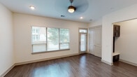 Located on Convergence Drive in Frisco, Texas, this two-story residence offers a thoughtfully designed layout spread across two levels. The main living area features rich dark hardwood flooring, large windows with horizontal blinds that invite abundant natural light, and a ceiling fan overhead. A transom-lit front entry door adds architectural character, while a built-in mudroom nook with dark cabinetry provides practical storage near the entrance.

The kitchen is well-appointed with dark espresso shaker-style cabinetry extending to the ceiling, a neutral tile backsplash, white quartz countertops, and a peninsula that serves as both a prep surface and casual dining space. Pendant lighting accents the peninsula, and stainless steel appliances—including a side-by-side refrigerator and dishwasher—complete the space.

Bathrooms feature light wood-look tile flooring, dark vanity cabinetry with white quartz surfaces, and tiled tub-shower combinations accented with mosaic tile borders. The primary bathroom includes a dual-sink vanity with a large framed mirror and brushed nickel fixtures.

Upstairs, carpeted bedrooms offer ceiling fans and generous natural light. A walk-in closet with multi-level shelving and hanging rods provides ample storage. Hallways connect bedrooms and bathrooms efficiently, making the upper level both functional and comfortable.