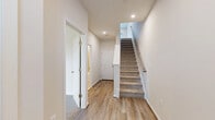 Located at 83 Terrace Green Dr in Barboursville, VA, this three-story home offers a thoughtfully designed layout across its floors. The entry level features a garage with a polished concrete floor and an automatic door, along with utility spaces. Light wood-style flooring and clean white walls flow through the main living level, where a combined dining, kitchen, and living area serves as the heart of the home. The kitchen is equipped with stainless steel appliances, including a French door refrigerator, electric range, and built-in microwave, complemented by rich dark cabinetry, light countertops, and a tile backsplash. The upper floors house four well-sized bedrooms, each featuring plush carpeting and windows that invite natural light and outdoor views. The generously sized primary bedroom includes a ceiling fan and multiple windows. Its en-suite bathroom offers tile flooring, dark wood vanity cabinetry, a glass-enclosed shower, and access to a walk-in closet. Additional bathrooms feature full tub-and-shower combinations with tiled surrounds and brushed nickel fixtures. Seven closets throughout provide exceptional storage, and a dedicated laundry room adds everyday convenience. Carpeted staircases with metal railings connect the three levels seamlessly.