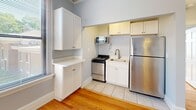 Located at 870 Vine St in Chattanooga, TN, this efficiently designed one-bedroom, one-bathroom unit offers a well-organized layout across a single floor. Warm hardwood flooring runs throughout the main living areas and bedroom, lending a classic, inviting character to the space.

The kitchen is thoughtfully appointed with stainless steel appliances, including a gas range, full-size refrigerator, and microwave. White cabinetry provides ample storage, and a large window allows generous natural light to fill the area, creating a bright and functional cooking space.

The spacious primary bedroom comfortably accommodates standard furnishings and features multiple windows with neighborhood views, a built-in closet with bifold doors, and sunlit hardwood floors that add warmth to the room's soft, neutral palette.

The bathroom is finished with classic octagonal mosaic tile flooring, a white vanity with under-cabinet storage, a framed mirror with an elegant multi-bulb light fixture, and a marble-style tiled shower surround, giving the space a clean and polished appearance.

Throughout the unit, light blue-gray walls complement the white trim and natural wood tones, creating a cohesive, calm aesthetic. Multiple windows ensure consistent natural light across all rooms, contributing to an open and airy feel throughout.
