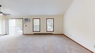 Located at 7609 Radcliffe Dr in Madison, WI, this 2-bedroom, 1-bathroom unit offers a well-designed single-floor layout with notable architectural character. The open living and kitchen area immediately impresses with dramatically vaulted ceilings and a ceiling fan overhead, creating an airy, expansive feel. A tile-surround fireplace anchors the living room, which features plush carpeting and connects seamlessly to the kitchen via a peninsula with a breakfast bar.

The kitchen is well-appointed with warm wood cabinetry, dark granite countertops, stainless steel appliances including a refrigerator and range, and tile flooring. Ample upper and lower cabinet storage lines both sides of the galley-style kitchen.

Both bedrooms are carpeted and offer generous closet space — the primary bedroom includes a walk-in closet, while the second bedroom features a bi-fold door closet. Multiple windows with dark wood trim allow natural light and views of surrounding greenery throughout the bedrooms.

The bathroom is clean and functional, finished with tile flooring, white cabinetry, and a full vanity with mirror. A stacked washer and dryer unit is conveniently housed within the bathroom. A hallway connects the main living areas to the bedrooms, completing this comfortable and efficiently arranged home.