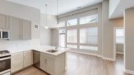 Located at 6223 N Rifle St in Denver, CO, this single-floor home offers four bedrooms, two bathrooms, and two closets designed with a clean, modern aesthetic. The open-concept kitchen is a standout feature, boasting tall vaulted ceilings, floor-to-ceiling windows that flood the space with natural light, and a large peninsula with a white quartz countertop, undermount sink, and elegant pendant lighting. Sage-toned shaker-style cabinetry lines the walls alongside a full suite of stainless steel appliances, including a gas range, built-in microwave, dishwasher, and French door refrigerator. Light wood-tone luxury vinyl flooring runs seamlessly throughout the entire home, creating a cohesive and contemporary feel. The bedrooms are bright and well-proportioned, each featuring windows with blinds and ceiling fans for comfort. The two bathrooms are finished with crisp white cabinetry, neutral quartz countertops, and light tile work — one featuring a tub/shower combination with large-format tile surround, and the other a walk-in shower with a framed mirror vanity and pendant lighting. The neutral color palette and modern finishes throughout create a calm, inviting atmosphere ideal for comfortable everyday living.