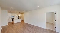 Located on Truelove Street in Sanford, NC, this single-story, 3-bedroom, 2-bathroom home offers a clean, modern design throughout. The open-concept kitchen and living area forms the heart of the home, with the kitchen showcasing white shaker cabinetry with matte black hardware, gleaming quartz countertops, a subway tile backsplash, stainless steel appliances including a range, microwave, and refrigerator, and a central island. The living room features durable wood-look flooring and recessed lighting, with large windows that fill the space with natural light. The bedrooms are carpeted for comfort and include ceiling fans, natural light from windows with blinds, and generous closet space — including walk-in closets outfitted with wire shelving systems. The primary bedroom offers a comfortable, well-proportioned layout. Both bathrooms are finished with white cabinetry, quartz countertops, subway-tiled tub-shower combinations, and matte black fixtures that add a contemporary touch. Wood-look flooring runs through the bathrooms and living areas, tying the home together with a cohesive aesthetic. The overall ambiance is bright, clean, and move-in ready.