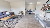 Located in Albuquerque, NM, this single-floor, three-bedroom, one-bathroom home offers a practical and well-appointed layout with clean, modern finishes throughout. The living room welcomes you with light luxury vinyl plank flooring, a large window that invites natural light, and a textured ceiling, creating a bright and comfortable gathering space. It flows seamlessly into the dedicated dining area, which features built-in shelving, a flush-mount light fixture, and easy access to the kitchen. The kitchen is efficiently designed with white shaker-style cabinetry, stainless steel appliances including a refrigerator and dishwasher, a double-basin sink, and durable countertops — offering ample storage and workspace. The three bedrooms are carpeted for comfort and feature neutral wall tones, with the primary bedroom offering a ceiling fan and a dedicated closet. The shared full bathroom includes a shower/tub combination and wood-look flooring consistent with the rest of the home. A hallway connects the private quarters and provides additional closet storage. The overall aesthetic is clean and contemporary, with a neutral color palette and consistent finishes that create a cohesive and move-in-ready environment throughout.