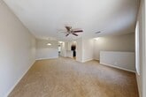 Located at 2801 NW 91st Ave in Coral Springs, FL, this one-bedroom, one-bathroom residence offers a well-organized and comfortable layout across a single floor. A carpeted staircase leads up to the entrance, setting the tone for the warm, neutral palette found throughout the home. The combined living and dining area is the centerpiece of the space, featuring plush wall-to-wall carpeting, ceiling fans, and generous natural light. Sliding glass doors open directly onto a private balcony with outdoor views of lush greenery, creating a seamless indoor-outdoor connection. The kitchen is equipped with rich dark wood cabinetry, light stone-toned countertops, a decorative tile backsplash, and black appliances, with a pass-through counter connecting it to the dining area. The spacious bedroom features carpeting, a ceiling fan, a large window with vertical blinds, and access to two closets, including a generously sized walk-in closet with built-in wire shelving. The bathroom includes a wood-toned vanity with stone countertops, a large mirror, and hardwood-style flooring. A dedicated laundry area with parquet-style flooring and overhead shelving adds everyday convenience to this well-appointed home.