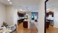 Located in Ooltewah, Tennessee, this well-appointed two-bedroom, one-bathroom single-story home offers a thoughtfully designed layout across a comfortable footprint. The kitchen is a standout feature, showcasing rich dark cabinetry, granite countertops, stainless steel appliances including a dishwasher, refrigerator, and range, a tile backsplash, pendant lighting, and a breakfast bar island — all set atop warm hardwood-style flooring. The living room is bright and welcoming, featuring plush carpeting, a ceiling fan, and a glass door that invites natural light while providing access to the outdoors. The primary bedroom is generously sized, offering carpeted floors, a ceiling fan, and a natural window view, complemented by a walk-in closet with built-in shelving and hanging rods. The second bedroom features a bold teal accent wall, carpeted floors, a ceiling fan, and a window with views of the surrounding area. The shared bathroom is finished with tile-surround tub and shower, hardwood-style flooring, and a dark vanity with countertop storage. A dedicated hallway connects all rooms efficiently, and two closets provide ample storage throughout the home.