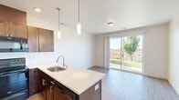 This well-appointed 2-bedroom, 2-bathroom residence at 1912 W A St in Pasco, WA offers a thoughtfully designed single-level layout with modern finishes throughout. The open-concept kitchen and living area serves as the heart of the home, featuring a large island with a stainless steel sink, white quartz countertops, dark shaker-style cabinetry, and a subway tile backsplash. Black and stainless appliances, including a range, over-the-range microwave, dishwasher, and refrigerator, complete the kitchen. Pendant lighting above the island adds a stylish focal point. Light wood-look flooring runs throughout the space, creating a warm, cohesive aesthetic. The living area is bright and airy, with a sliding glass door that opens to a private balcony offering views of the surrounding neighborhood. Both bedrooms are comfortably sized, with the primary bedroom providing ample space, a dedicated closet, and a wall-mounted mini-split system for individual climate control. Each bedroom features natural light through sizable windows. The two bathrooms are clean and modern, with light wood flooring, white vanities, and tub-shower combinations accented by matte black hardware. Two closets provide practical storage throughout the residence.