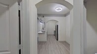 This contemporary single-floor home showcases an open concept design with a seamless flow between rooms. Arched doorways and recessed lighting add architectural interest, while light gray wood-look flooring creates a cohesive look throughout. The kitchen boasts white cabinetry, stainless steel appliances, and a central island. Bedrooms feature ceiling fans and large windows, offering ample natural light. Bathrooms are equipped with modern fixtures and vanities. The property's neutral color palette and clean lines contribute to a fresh, inviting ambiance. With its thoughtful layout and updated amenities, this residence offers a blend of style and functionality.