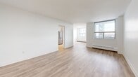 Located on the 11th floor at 2450 Weston Rd in Toronto, this well-appointed 2-bedroom, 1-bathroom unit offers a clean, modern aesthetic throughout. Light wood laminate flooring runs seamlessly across all living areas, complemented by crisp white walls that create a bright, airy atmosphere.

The open living area is generously proportioned, featuring large windows that invite abundant natural light and offer views of the surrounding cityscape. The layout connects the living space to a separate kitchen, which is equipped with white shaker-style cabinetry, a subway tile backsplash, rich brown countertops, and stainless steel appliances including a refrigerator and dishwasher.

The spacious primary bedroom is notably large, accommodating a variety of furniture arrangements, and includes a mirrored sliding-door closet for ample storage. The second bedroom is well-sized with its own window and baseboard heating. Both bedrooms feature the same consistent light wood flooring and neutral finishes found throughout the unit.

The bathroom is finished with classic white subway tile surrounding a full soaker tub with an overhead shower, paired with chrome fixtures for a clean, timeless look. Baseboard heating is present throughout, ensuring year-round comfort in this thoughtfully updated Toronto residence.