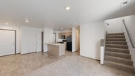 Located at 3780 N Yukon Ave in Sioux Falls, South Dakota, this two-story home offers a well-organized layout spread across two floors. The main level features an open-concept living and kitchen area, where wood-look flooring transitions seamlessly into plush carpet in the living space. The kitchen is equipped with light wood cabinetry, black appliances including a refrigerator, range, and microwave, and a peninsula with a sink that overlooks the living area. A sliding glass door floods the living room with natural light and provides outdoor access. A staircase connects the main floor to the upper level. The upper floor houses both bedrooms, two full bathrooms, a hallway, and two closets. The primary bedroom is generously sized with soft carpet flooring. The second bedroom also features carpet and a window with neighborhood views. Both bathrooms are finished with wood-look tile flooring, vanities with light countertops, and full tub-shower combinations. The hallway bathroom includes a large mirror and ample vanity storage. Throughout the home, a clean, neutral color palette of white walls and warm-toned finishes creates a bright and cohesive atmosphere well-suited for comfortable everyday living.