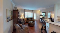 This single-floor residence offers a thoughtfully designed layout with a warm, neutral color palette and a seamless flow between living spaces. The living room serves as the heart of the home, featuring rich hardwood flooring, crown molding, and a patio door that invites natural light. The space comfortably accommodates multiple seating arrangements and connects directly to a separate dining area, which is highlighted by additional crown molding and chair rail detailing.

The kitchen is efficiently laid out with white cabinetry, granite countertops, stainless steel appliances, and hardwood flooring, providing ample storage and functionality. The primary bedroom features plush carpeting, a ceiling fan, and access to an adjacent room, creating a comfortable and private retreat. A second bedroom also offers carpeted floors, a ceiling fan, and multiple windows that allow for generous natural light.

Both bathrooms are finished with granite-topped vanities and white cabinetry. One bathroom includes a tub-shower combination with hardwood flooring, while the other features a well-lit vanity mirror and matching hardwood floors. Together, these spaces create a cohesive, comfortable residence with consistent finishes and a welcoming ambiance throughout.