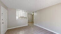 Located at 4601 Packard Dr in Nashville, TN, this 2-bedroom, 1-bathroom unit offers a practical and comfortable single-floor layout. The combined living and dining area is bright and open, featuring light-toned luxury vinyl plank flooring throughout, neutral warm-beige walls, textured ceilings, and a ceiling fan. A sliding glass door fills the living space with natural light and provides direct access to an outdoor area. The kitchen is accessible via a distinctive pass-through window with a glass block partition, adding a unique architectural detail. It is equipped with white cabinetry, granite-style countertops, a double-basin stainless steel sink, white appliances including a range, dishwasher, and refrigerator, and a dedicated dining area. Both bedrooms are well-sized, each featuring ceiling fans, windows with blinds for natural light, and the same consistent LVP flooring. The full bathroom includes a granite-topped vanity, a tub/shower combination, and a textured ceiling. A hallway connects the bedrooms to the main living areas, and a dedicated closet provides additional storage. The unit maintains a clean, cohesive aesthetic throughout with consistent neutral tones and modern finishes.
