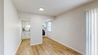 Located at 4592 Channing Terrace in Columbus, Ohio, this two-bedroom, one-bathroom single-floor home offers a clean, updated interior with a cohesive neutral palette throughout. The living room is bright and welcoming, featuring light hardwood flooring and a sliding glass door with vertical blinds that allows natural light to fill the space. The kitchen is well-appointed with white shaker-style cabinetry, light granite countertops, stainless steel appliances including an electric range and full-size refrigerator, and a window overlooking greenery outside. Both bedrooms are carpeted with plush gray carpet, neutral walls, and windows that bring in natural light. The primary bedroom includes a double sliding-door closet and black hardware accents. The full bathroom is thoughtfully finished with warm hardwood-style flooring, a white vanity with ample cabinet storage, a tub-shower combination, and matte black hardware and fixtures throughout, adding a modern touch. A hallway connects the main living areas to the bedrooms and bathroom, providing a practical and efficient layout. The overall design is clean, modern, and move-in ready, with consistent finishes creating a cohesive look across the entire home.