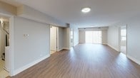 This single-floor residence offers a thoughtfully designed layout that balances comfort and functionality throughout. The open-concept living and dining area is finished with warm hardwood-style flooring and neutral gray walls, creating a bright and versatile space anchored by large windows with vertical blinds that invite natural light. The kitchen is a standout feature, showcasing rich warm-toned cabinetry extending to the ceiling, granite countertops, a central island, and a full suite of stainless steel appliances including a refrigerator, range, microwave, and dishwasher — all set atop tile flooring that transitions seamlessly from counter to cabinet.

The bedrooms are carpeted for comfort, each presenting a clean, neutral palette with ample wall space. One bedroom includes a built-in closet with double bi-fold doors and integrated shelving, while another features a window with exterior views. Both bathrooms are finished with granite-topped vanities, rich wood cabinetry, large mirrors, and tile flooring. One bathroom includes a walk-in shower with a curtain rod enclosure, while the second features a tub-shower combination. Throughout the residence, consistent finishes and a cohesive design create a polished, move-in-ready environment.