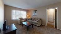 Located in the Crenshaw neighborhood of Los Angeles, this single-floor, 2-bedroom, 1-bathroom home offers a practical and comfortable layout throughout. The living room features plush carpeting, large vertical-blind windows that invite natural light, and an open flow into the dining area. The dining space accommodates a round table for four and is accented by hardwood flooring and a ceiling fan overhead. The kitchen is well-appointed with white cabinetry, stainless steel countertops, a gas range, and a double-basin sink beneath a window overlooking greenery outside. Ample upper and lower cabinet storage adds to its functionality. Both bedrooms are carpeted and include ceiling fans, vertical-blind windows for light control, and closet space. The primary bedroom is generously sized, while the secondary bedroom offers enough room for a bed and a work desk. The shared bathroom features stone-look tile flooring, a vanity with storage, a bathtub, and a window with blinds for natural ventilation. Throughout the home, warm neutral tones and consistent finishes create a cohesive and inviting atmosphere well-suited for comfortable everyday living in Los Angeles.