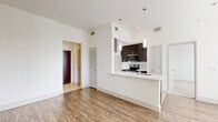 Located at 2222 Smith St in Houston, TX, this one-bedroom, one-bathroom unit offers a thoughtfully designed single-floor layout that maximizes functionality and comfort. The open-concept living and dining area is bathed in natural light from large windows with blinds, and features warm hardwood-style flooring that flows throughout the main living spaces. The kitchen serves as a central hub, showcasing dark espresso cabinetry, stainless steel appliances including a range, microwave, and refrigerator, and a peninsula with a built-in sink and pendant lighting above — ideal for casual dining or entertaining. A dedicated office provides a versatile workspace separate from the main living areas. The bedroom is carpeted for comfort and connects directly to the full bathroom, which features a long vanity with dual sinks, dark cabinetry, a large mirror, tile flooring, and a walk-in tiled shower with decorative tile accents. Generous storage is provided throughout, with four closets including a spacious walk-in closet outfitted with wire shelving. Additional conveniences include an in-unit laundry area and a pantry. The clean white walls and consistent design palette give the entire space a bright, modern, and cohesive ambiance.