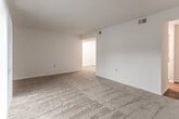 Located on Sassafras Court in Virginia Beach, Virginia, this single-story home offers a straightforward, functional layout designed for comfortable everyday living. The interior is finished with a neutral, clean palette of white walls and warm beige carpeting throughout the main living and sleeping areas, creating a bright and cohesive feel.

The living area is generously proportioned, offering ample space for a variety of furniture arrangements. A sliding glass door fitted with vertical blinds opens to an outdoor area, allowing natural light to fill the room and providing a connection to the exterior. An adjacent area provides additional flexible space, supported by ceiling vents for consistent climate control.

The bedrooms are well-sized and carpeted, each featuring a standard closet with shelving and hanging rods for organized storage. Windows with blinds admit natural light while maintaining privacy. Ceiling-mounted light fixtures provide reliable overhead illumination.

The kitchen transitions to hardwood-style flooring and includes warm wood-toned cabinetry, granite-look countertops, and white appliances. A hallway connects the kitchen to the rest of the home seamlessly.

The bathroom features a full-sized white tub and shower combination with chrome fixtures, complemented by wood-look flooring, offering a clean and practical space.