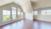 Located at 26 Lakeshore Dr in Canandaigua, NY, this well-appointed 2-bedroom, 2-bathroom residence offers a thoughtfully designed single-floor layout with generous living space. The architecture is defined by striking vaulted ceilings that soar throughout key areas, creating an open, airy atmosphere enhanced by abundant natural light streaming through multiple large windows.

The primary bedroom is notably spacious, featuring vaulted ceilings, rich hardwood flooring, and a bank of windows that frame scenic views of Canandaigua Lake. A large walk-in closet with built-in wire shelving provides ample storage. The second bedroom also showcases vaulted ceilings and plush carpeting, with a window offering outdoor views.

The kitchen is well-equipped with rich dark cabinetry, white quartz countertops, stainless steel appliances including a refrigerator, range, and microwave, and warm hardwood floors that extend into the open dining and living areas. A glass-paneled door leads to an outdoor area with direct lake views, seamlessly blending indoor and outdoor living.

Both bathrooms feature neutral tile flooring and dark vanity cabinetry. The overall color palette throughout is warm and neutral, complementing the natural light and lakeview setting.
