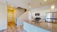 Located at 1545 Timberstop Street in Lancaster, Ohio, this two-story home offers a thoughtfully designed layout with modern finishes throughout. The main level features an open-concept kitchen and living area with durable wood-look flooring. The kitchen is outfitted with crisp white cabinetry, granite countertops, a central island with an undermount sink, stainless steel appliances including a refrigerator, electric range, and over-the-range microwave, and pendant lighting that adds a contemporary touch. A staircase connects the main level to the upper floor, where carpeted bedrooms provide a comfortable retreat. Multiple bedrooms feature natural light from windows with exterior views of the surrounding neighborhood. The upper level includes bathrooms finished with granite-topped white vanities; the primary bath offers a dual-sink vanity, while the secondary bath includes a tub-shower combination. A dedicated utility space houses the water heater, HVAC system, and laundry hookups, ensuring practical functionality. Textured ceilings and neutral-toned walls are consistent throughout, creating a clean, cohesive aesthetic well-suited to a variety of interior styles.