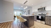 Located at 28 Westhill Dr in Waterloo, Ontario, this thoughtfully designed 2-bedroom, 3-bathroom unit offers a contemporary open-concept layout on a single floor. The kitchen is a standout feature, showcasing two-toned cabinetry with sleek white upper cabinets and dark wood-finish lower cabinets, a subway tile backsplash, stainless steel appliances, and a central island with a white quartz countertop and bar seating — ideal for both cooking and casual dining. The kitchen flows seamlessly into the living area, which features light luxury vinyl plank flooring throughout, neutral grey walls, and a sliding door providing access to the outdoors and ample natural light. The primary bedroom is a comfortable retreat with a large window offering scenic outdoor views and rich hardwood-style flooring. The second bedroom is equally well-appointed with natural light and a clean, modern aesthetic. Three bathrooms serve the unit: one features a full soaker tub with white subway tile surround, while another includes a modern vanity with dark wood cabinetry and a white countertop. A hallway connects the rooms efficiently, completing this well-organized and stylishly finished space.
