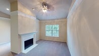 Located at 201 E Round Grove Rd in Lewisville, Texas, this single-floor residence offers a well-organized layout with comfortable living spaces and thoughtful architectural details throughout. The living area is a welcoming focal point, featuring a classic white-mantled fireplace, plush carpeting, crown molding, and a decorative ceiling light fixture. Vaulted ceilings in select areas add a sense of openness and volume to the space. A sliding glass door leads to a private balcony overlooking lush greenery, filling the living area with natural light and outdoor views.

The kitchen is efficiently designed with white cabinetry, granite-style countertops, a stone tile backsplash, and black appliances including a refrigerator, range, and microwave. A peninsula breakfast bar with seating connects the kitchen to the adjoining living and dining areas, making it ideal for casual dining and entertaining.

The bedrooms are generously sized, each featuring carpet flooring, ceiling fans, and windows with exterior views of surrounding trees. Crown molding adds a refined touch to the rooms. The bathroom includes a soaking tub and shower combination with classic white tile accented by a bold navy border, complemented by wood-style flooring and ample cabinetry for storage.