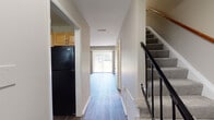 Located at 6417 Statute St in Chesterfield, VA, this two-story residence offers a practical and comfortable layout across two levels. The main floor features durable hardwood-style flooring that runs throughout the entry corridor, kitchen, and living areas, creating a cohesive and easy-to-maintain aesthetic. The kitchen is well-appointed with light maple cabinetry, granite-style countertops, a stainless steel sink with a pull-down faucet, and black appliances including a refrigerator and dishwasher. The living area at the end of the main corridor is bright and open, highlighted by a full-width sliding glass door with vertical blinds that floods the space with natural light and provides direct access to the outdoors. A carpeted staircase with a metal railing leads to the upper level, where multiple bedrooms are finished with plush carpeting and neutral-toned walls. Each bedroom offers ample space, with some featuring ceiling fans, closets, and windows that bring in natural light. A full bathroom includes a tub/shower combination, a vanity with wood cabinetry, and hardwood-style flooring. The overall design is clean, neutral, and move-in ready, offering a comfortable living environment in a residential Chesterfield neighborhood.