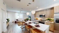 Located in Phoenix, AZ, this thoughtfully designed one-bedroom, one-bathroom residence offers a cohesive open-concept layout finished with contemporary details and warm, neutral tones throughout. Light wood-style flooring runs seamlessly across the entire space, enhancing the bright and airy atmosphere.

The kitchen is a standout feature, showcasing light wood cabinetry, a tile backsplash, stainless steel appliances, and a generous island with a white quartz countertop and bar seating for three. Globe pendant lights overhead add a modern, inviting touch. The kitchen flows directly into the dining and living areas, creating a connected, social atmosphere ideal for everyday living. The living room benefits from multiple windows and a ceiling fan, filling the space with natural light and a comfortable ambiance.

The bedroom is a peaceful retreat, featuring dual windows with sheer curtains, a ceiling fan, and ample room for a full furniture arrangement. An adjacent walk-in closet provides well-organized storage with built-in shelving and hanging rods. The bathroom is clean and functional, offering a combined tub and shower, a wood-tone vanity with a white countertop, and an illuminated mirror. Every room reflects a consistent modern aesthetic, making this a polished and practical Phoenix residence.