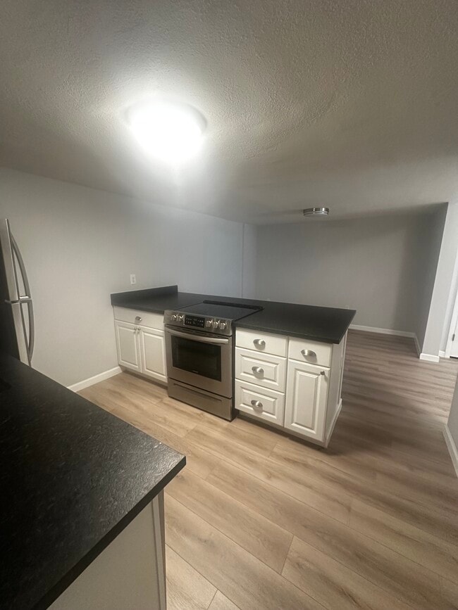 View of the island with seating just on the other side and room for a kitchen table and chairs. - 12170 Huron St