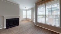 Located at 2734–2736 Gaston Ave in Dallas, TX, this single-story unit offers a well-organized layout with a variety of functional living spaces. The living room serves as a central gathering area, featuring hardwood-style flooring, crown molding, a ceiling fan, and a tiled fireplace framed by large windows fitted with horizontal blinds. Natural light flows generously into the room, with views of the surrounding outdoor environment visible through the oversized windows and access to a balcony area.

The kitchen is outfitted with rich, dark wood cabinetry, granite-style countertops, a stainless steel range with an over-the-range microwave, and a double-basin sink. Wood-look flooring and ample upper and lower cabinet storage make it both practical and visually appealing.

The bedrooms feature plush wall-to-wall carpeting, ceiling fans, and natural light from blinds-fitted windows. The primary bathroom includes a dual-sink vanity with dark cabinetry, a tub-shower combination with tiled surround, wood-look flooring, and direct access to a walk-in closet. A secondary bathroom also provides a tiled tub-shower combo. A dedicated laundry area with hookups and shelving rounds out the unit's practical amenities.