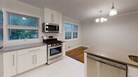 Located at 41 Constantine Pl in Summit, NJ, this two-floor home combines classic architectural details with modern updates to create a clean, functional living environment. Rich hardwood flooring flows consistently throughout the main and upper levels, lending warmth and continuity to the space.

The main level features a welcoming living area accented by crown molding, neutral gray walls, and natural light from double-hung windows. A staircase connects seamlessly to the upper floor. The adjacent dining area opens directly into a well-appointed kitchen, which is a standout feature of the home. The kitchen is outfitted with white shaker-style cabinetry, gray quartz-style countertops, stainless steel appliances including a gas range, built-in microwave, dishwasher, and refrigerator, along with a peninsula for additional prep space. Light porcelain tile flooring and a chandelier over the dining area complete the space.

The upper level offers multiple bedrooms, each with hardwood floors, neutral walls, and windows providing natural light and outdoor views. Closet space is present in the bedrooms. The bathroom is tastefully renovated with light wood-look tile flooring, white vanity cabinetry, a quartz countertop, and a glass-enclosed shower, offering a clean, contemporary finish throughout.