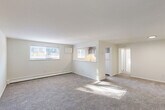 Located at 400 S Lansdowne Ave in Yeadon, PA, this one-bedroom, one-bathroom unit offers a functional and well-laid-out single-floor plan. The spacious living room greets you with neutral-toned carpet, bright white walls, and multiple windows that allow natural light to pour in, creating a clean and airy atmosphere. A baseboard heating system runs along the walls throughout the unit, providing efficient climate control. The kitchen is positioned adjacent to the living area and features a pass-through counter opening, dark cabinetry, a white refrigerator, and a sink with a window, offering a connected feel to the main living space. A hallway leads to the generously sized bedroom, which is carpeted and includes a dedicated closet with louvered doors, a window for natural light, and a baseboard heater. Two closets provide ample storage throughout the unit. The full bathroom is finished with wood-look tile flooring, a white vanity with sink, a mirror, and a tub and shower combination with a curtain rod and a window for ventilation. The overall aesthetic of the unit is clean, bright, and neutral, making it a versatile and move-in-ready space.