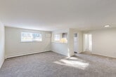 Located at 400 S Lansdowne Ave in Yeadon, PA, this one-bedroom, one-bathroom unit offers a functional and well-laid-out single-floor plan. The spacious living room greets you with neutral-toned carpet, bright white walls, and multiple windows that allow natural light to pour in, creating a clean and airy atmosphere. A baseboard heating system runs along the walls throughout the unit, providing efficient climate control. The kitchen is positioned adjacent to the living area and features a pass-through counter opening, dark cabinetry, a white refrigerator, and a sink with a window, offering a connected feel to the main living space. A hallway leads to the generously sized bedroom, which is carpeted and includes a dedicated closet with louvered doors, a window for natural light, and a baseboard heater. Two closets provide ample storage throughout the unit. The full bathroom is finished with wood-look tile flooring, a white vanity with sink, a mirror, and a tub and shower combination with a curtain rod and a window for ventilation. The overall aesthetic of the unit is clean, bright, and neutral, making it a versatile and move-in-ready space.