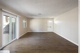 Located at 2002 E Santa Clara Ave in Santa Ana, CA, this single-story, 2-bedroom, 2-bathroom home offers a well-organized layout across a comfortable footprint. The living room serves as the heart of the home, highlighted by a white brick corner fireplace and light wood-look flooring. Sliding glass doors open directly to a private patio, while an additional window invites generous natural light and outdoor views. The kitchen is configured in a galley style, featuring white cabinetry, white tile backsplash, a double stainless steel sink, coil cooktop, oven, and a dishwasher — providing ample storage and workspace. A dining area adjoins the kitchen for convenient everyday living. The primary bedroom offers a spacious retreat with plush carpeting, a mirrored sliding closet, and a dedicated en-suite bathroom. The en-suite includes a tub-shower combination with a framed vanity mirror and stone-look countertop. A second bathroom features a walk-in glass shower stall and includes a stacked in-unit washer and dryer, adding exceptional convenience. The second bedroom also features wood-look flooring and a window with neighborhood views. Neutral tones, textured ceilings, and consistent finishes throughout lend the home a clean, cohesive aesthetic.