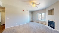 Located at 11469 W Burgundy Ave in Littleton, CO, this well-appointed one-bedroom, one-bathroom residence offers a comfortable and functional single-floor layout. The living room serves as the heart of the home, featuring plush carpeting, a ceiling fan with light fixture, and a tile-surround fireplace with a classic mantle niche — ideal for Colorado evenings. A large window invites natural light and provides views of the surrounding community. The living area flows seamlessly into a dedicated dining space and an efficiently designed kitchen outfitted with white shaker cabinetry, light countertops, wood-look flooring, and a full suite of stainless steel appliances including a refrigerator, gas range, over-the-range microwave, and dishwasher. The spacious bedroom offers carpet flooring, a ceiling fan, and a double-door closet providing generous storage. An additional closet offers further organizational flexibility. The bathroom is finished with a white vanity, wood-look tile flooring, and a tiled tub-shower combination. Additional highlights include an in-unit laundry area, a private balcony, and a connecting hallway that ties the layout together efficiently. Neutral tones throughout create a clean, move-in-ready atmosphere.