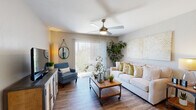 Located at 201 N Wilmot Rd in Tucson, Arizona, this well-appointed single-floor residence offers a comfortable and cohesive living experience throughout its thoughtfully designed layout. The living room serves as the heart of the home, featuring durable wood-style flooring, a ceiling fan with integrated lighting, and large sliding glass doors dressed with vertical blinds that flood the space with natural light and provide access to an outdoor patio. The kitchen is outfitted with crisp white cabinetry, subway tile backsplash, a central island with a light wood countertop, recessed lighting, and black appliances. A sliding barn door adds a stylish accent leading to an adjacent pantry or utility area. The dining nook offers an intimate setting highlighted by a chandelier, built-in shelving, and warm wood-style flooring. The bedrooms feature plush carpeting, ceiling fans, and ample natural light from windows, creating restful and welcoming retreats. The bathroom includes a tub-shower combination with wood-style flooring, maintaining the home's consistent aesthetic. Throughout, neutral tones, warm accents, and practical finishes come together to create a bright, inviting atmosphere well-suited to everyday living in the Tucson climate.