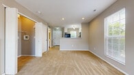 Located at 3419 Heritage Glen Dr in Grove City, Ohio, this two-story, 2-bedroom, 2-bathroom home offers a practical and comfortable layout spread evenly across two floors. The main level features an open-concept living room and kitchen area, where warm neutral-toned walls and plush carpeting create an inviting atmosphere. A white-mantled fireplace serves as a focal point in the living room, complemented by a large window that draws in natural light and provides views of the surrounding neighborhood. The kitchen includes tile flooring, a stainless steel refrigerator, and a window overlooking greenery outside. A staircase connects the main floor to the upper level, where both bedrooms are situated. The primary bedroom features vaulted ceilings, two windows for ample natural light, and access to a walk-in closet. The second bedroom is similarly well-lit with carpeted floors and a window view. The upper hallway provides convenient access to both bedrooms and the staircase. Both bathrooms are well-appointed; one features tile flooring, a white vanity with storage, a full tub-shower combination, and a large mirror. A dedicated laundry room and a closet round out the home's functional amenities, making this a well-organized and efficient living space.