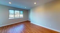 Located at 615 Healdsburg Ave in Santa Rosa, CA, this apartment on the second floor presents a thoughtfully designed single-level layout with a cohesive blend of comfort and functionality. The open living area features rich hardwood flooring, recessed lighting, and large windows that invite an abundance of natural light and views of the surrounding greenery.

The kitchen is a standout feature, showcasing warm wood cabinetry, dark granite countertops, stainless steel appliances including a refrigerator and microwave, and a peninsula with bar seating — ideal for casual dining or entertaining. Pendant lighting above the peninsula adds a refined touch.

The bedrooms offer a contrast in flooring, with plush carpeting underfoot. One bedroom includes a sliding glass door that opens directly to a private balcony, providing pleasant outdoor views. The bathrooms are well-appointed with granite countertops, wood cabinetry with brushed nickel hardware, large mirrors, and recessed medicine cabinet storage.

Throughout the unit, clean white baseboards and neutral wall tones create a bright, move-in-ready atmosphere. The overall layout flows naturally from the living and kitchen areas toward the private bedrooms and baths, making this apartment a functional and inviting residence in Santa Rosa.