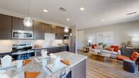 Located at Trek Trail Heights in Colorado Springs, CO, this thoughtfully designed 1-bedroom, 1-bathroom residence offers a modern, open-concept layout that maximizes every inch of its well-utilized floor plan. The combined kitchen and living area serves as the heart of the home, featuring warm wood-look flooring that flows seamlessly throughout. The kitchen is outfitted with dark espresso cabinetry, a white subway tile backsplash, granite countertops, stainless steel appliances, and a center island with pendant lighting — ideal for both cooking and casual dining. The living room is bathed in natural light from large windows with exterior views, creating a bright and welcoming atmosphere. The bedroom offers a comfortable, well-proportioned retreat complete with a ceiling fan, large window, and two closets providing ample storage. The bathroom features an extended vanity with granite countertops, dark cabinetry, and a tub-shower combination. Neutral tones and clean architectural lines are consistent throughout, lending the space a cohesive, contemporary aesthetic. The overall ambiance is warm and inviting, blending functional design with refined finishes suited for modern living in Colorado Springs.